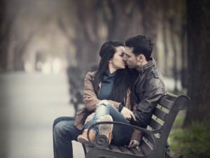 Par kysser på en bænk i parken - romantik